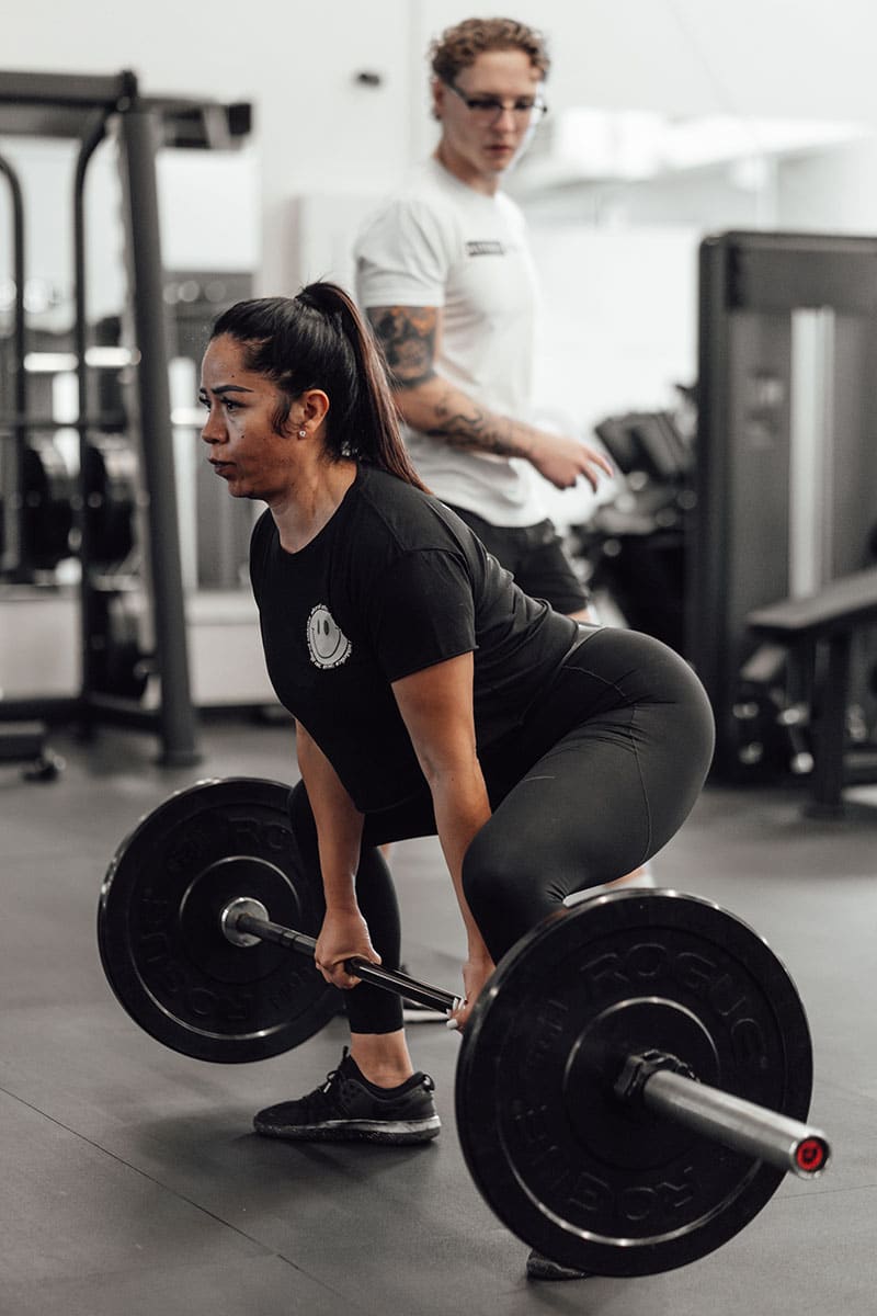woman strength training in Altered Athletics gym in small group class